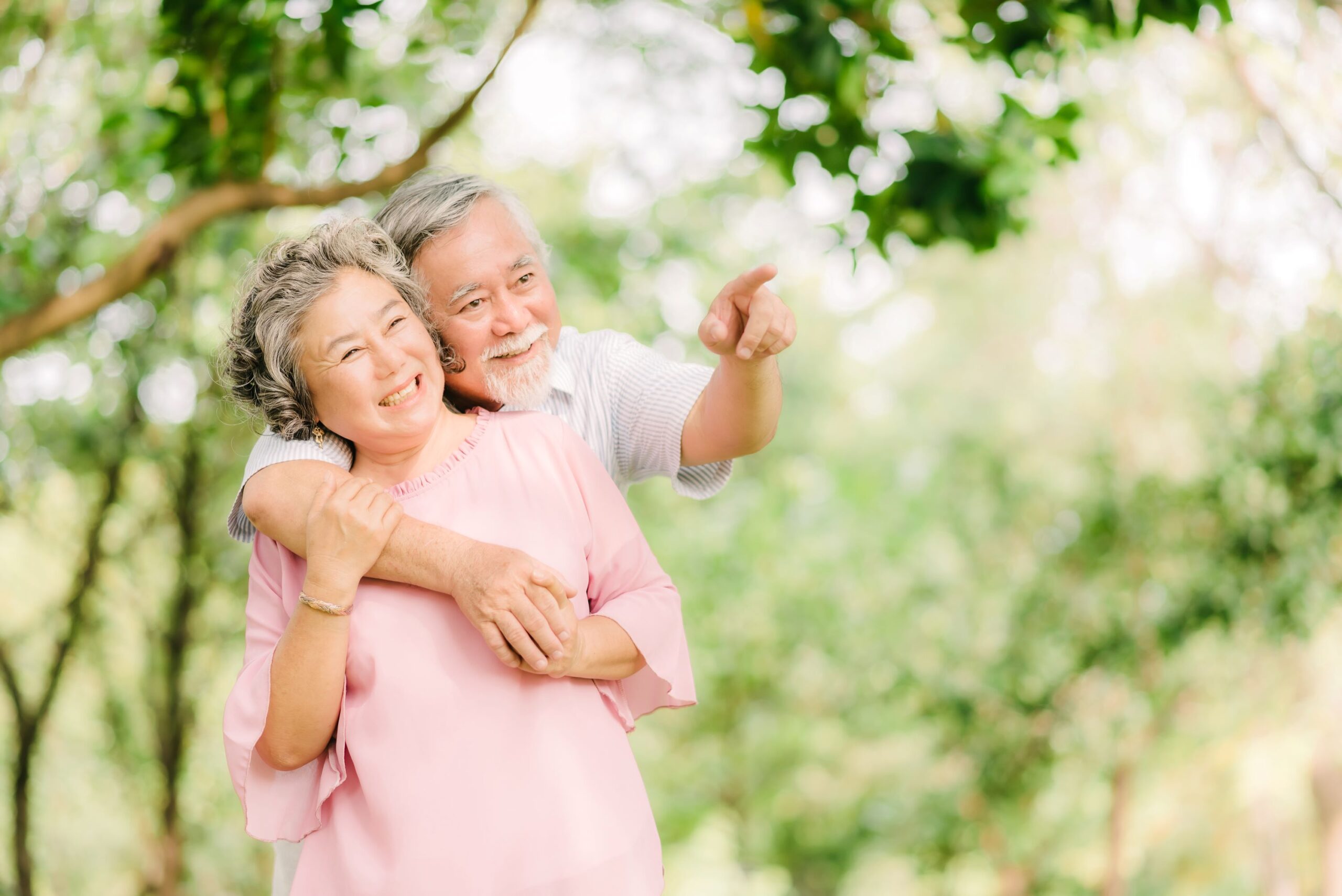 Happy older Asian couple embracing outdoors